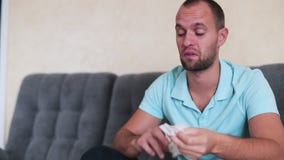 Retrato del individuo atractivo con un espray nasal y del tejido en manos, usando descensos de nariz, concepto de tratamiento par almacen de video Retrato del individuo atractivo con un espray nasal y del tejido en manos, usando descensos de nariz, concepto de tratamiento par almacen de video
