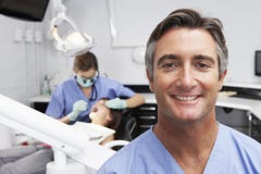 Retrato del paciente dental de With Dentist Examining de la enfermera en fondo imágenes de archivo libres de regalías Retrato del paciente dental de With Dentist Examining de la enfermera en fondo imágenes de archivo libres de regalías