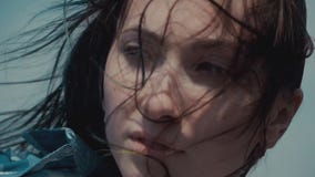Retrato del primer de la mujer atractiva encantadora que mira la cámara fuera de la luz soleada del día de verano en el fondo ale almacen de metraje de vídeo Retrato del primer de la mujer atractiva encantadora que mira la cámara fuera de la luz soleada del día de verano en el fondo ale almacen de metraje de vídeo