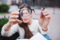 Retrato del primer de mujeres jovenes con los vidrios Ella tiene problemas de la vista y está bizqueando sus ojos un poco La much imágenes de archivo libres de regalías Retrato del primer de mujeres jovenes con los vidrios Ella tiene problemas de la vista y está bizqueando sus ojos un poco La much imágenes de archivo libres de regalías