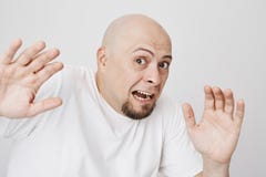 Retrato del primer del varón calvo aterrorizado que aumenta las manos como si vea algo asustadizo e intenta a la defensa, mirando foto de archivo Retrato del primer del varón calvo aterrorizado que aumenta las manos como si vea algo asustadizo e intenta a la defensa, mirando foto de archivo