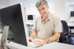 Retrato del profesor feliz que trabaja en el ordenador fotos de archivo libres de regalías Retrato del profesor feliz que trabaja en el ordenador fotos de archivo libres de regalías