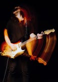Retrato do estúdio: músico considerável da rocha do homem novo com o cabelo longo que joga a guitarra elétrica Efeito obscuro do foto de stock royalty free Retrato do estúdio: músico considerável da rocha do homem novo com o cabelo longo que joga a guitarra elétrica Efeito obscuro do foto de stock royalty free