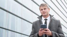 Retrato do homem de negócio considerável que usa o smartphone e beber imagem de stock Retrato do homem de negócio considerável que usa o smartphone e beber imagem de stock