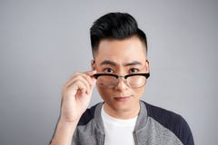 Retrato do homem moderno chocado que toca em seus espetáculos imagem de stock Retrato do homem moderno chocado que toca em seus espetáculos imagem de stock