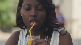 Retrato do suco bebendo da mulher afro nova da virada fora no café vídeos de arquivo Retrato do suco bebendo da mulher afro nova da virada fora no café vídeos de arquivo