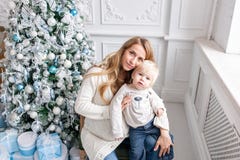 Retrato feliz de la familia en hogar - la madre embarazada de los jóvenes abraza a su pequeño hijo Feliz Año Nuevo Árbol de navid foto de archivo Retrato feliz de la familia en hogar - la madre embarazada de los jóvenes abraza a su pequeño hijo Feliz Año Nuevo Árbol de navid foto de archivo