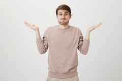 Retrato interno do homem europeu considerável com cerda e mãos de espalhamento do corte de cabelo à moda, mostrando não tiver nen imagem de stock Retrato interno do homem europeu considerável com cerda e mãos de espalhamento do corte de cabelo à moda, mostrando não tiver nen imagem de stock