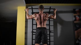Retrato trasero de la visión de un hombre muscular que aprieta en el estudio del gimnasio almacen de metraje de vídeo Retrato trasero de la visión de un hombre muscular que aprieta en el estudio del gimnasio almacen de metraje de vídeo