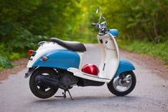 Retro motorino blu nella foresta con il casco fotografia stock libera da diritti Retro motorino blu nella foresta con il casco fotografia stock libera da diritti