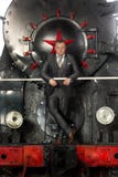 Retro styled businessman in suit posing on steam locomotive stock photo Retro styled businessman in suit posing on steam locomotive stock photo