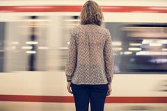 Retrovisione di una donna bionda che aspetta al binario del treno immagine stock Retrovisione di una donna bionda che aspetta al binario del treno immagine stock