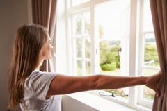 Rideaux se tenants prêt en fenêtre et en ouverture de chambre à coucher de femme image libre de droits Rideaux se tenants prêt en fenêtre et en ouverture de chambre à coucher de femme image libre de droits