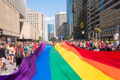 Riesige homosexuelle Regenbogenflagge über der Straße an der Schwulenparade lizenzfreie stockbilder Riesige homosexuelle Regenbogenflagge über der Straße an der Schwulenparade lizenzfreie stockbilder