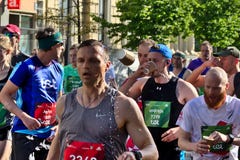 Riga, Letland - Mei 19 2019: Het drinkwater van marathonagenten in grote menigte stock afbeelding Riga, Letland - Mei 19 2019: Het drinkwater van marathonagenten in grote menigte stock afbeelding