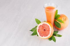 Rijpe grapefruits met halve plak, groen bladeren en sap op zachte witte houten raad Gezonde vruchten de zomerachtergrond Stock Fotografie Rijpe grapefruits met halve plak, groen bladeren en sap op zachte witte houten raad Gezonde vruchten de zomerachtergrond Stock Fotografie