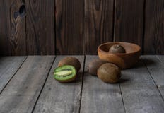 Rijpe kiwi op een houten achtergrond in een houten kom royalty-vrije stock afbeelding Rijpe kiwi op een houten achtergrond in een houten kom royalty-vrije stock afbeelding