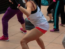 Rimini, Itália - podem 2016: Moça com short e camiseta de alças branca: Exercício do encaixotamento da aptidão com saco de perfur foto de stock Rimini, Itália - podem 2016: Moça com short e camiseta de alças branca: Exercício do encaixotamento da aptidão com saco de perfur foto de stock