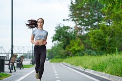 Rinnande asiatisk kvinna på stranden Jogga för morgon Idrottsman nendreven royaltyfria bilder Rinnande asiatisk kvinna på stranden Jogga för morgon Idrottsman nendreven royaltyfria bilder