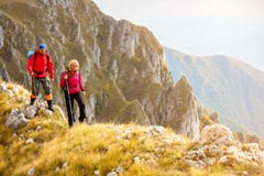 Risquez, voyagez, tourisme, hausse et concept de personnes - couple de sourire marchant avec des sacs à dos dehors photographie stock Risquez, voyagez, tourisme, hausse et concept de personnes - couple de sourire marchant avec des sacs à dos dehors photographie stock