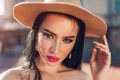 Ritratto all'aperto di bella donna castana con il cappello d'uso di trucco Modello femminile sexy fotografia stock libera da diritti Ritratto all'aperto di bella donna castana con il cappello d'uso di trucco Modello femminile sexy fotografia stock libera da diritti