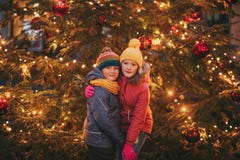 Ritratto all'aperto di piccoli bambini accanto all'albero di Natale con le luci fotografie stock Ritratto all'aperto di piccoli bambini accanto all'albero di Natale con le luci fotografie stock