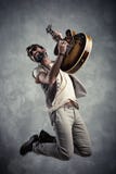 Ritratto caucasico adulto del chitarrista che gioca chitarra elettrica e che salta sul fondo di lerciume Concetto moderno del can immagini stock libere da diritti Ritratto caucasico adulto del chitarrista che gioca chitarra elettrica e che salta sul fondo di lerciume Concetto moderno del can immagini stock libere da diritti