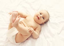 Ritratto del bambino sorridente sveglio che si trova sul letto fotografia stock Ritratto del bambino sorridente sveglio che si trova sul letto fotografia stock