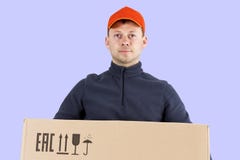 Ritratto del lavoratore di servizio di distribuzione isolato su fondo blu il corriere tiene la scatola di cartone in sue mani Ser fotografie stock libere da diritti Ritratto del lavoratore di servizio di distribuzione isolato su fondo blu il corriere tiene la scatola di cartone in sue mani Ser fotografie stock libere da diritti
