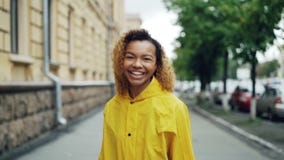 Ritratto del movimento lento dell'adolescente afroamericano che cammina nella via, girantesi verso la macchina fotografica ed esa video d archivio Ritratto del movimento lento dell'adolescente afroamericano che cammina nella via, girantesi verso la macchina fotografica ed esa video d archivio