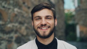 Ritratto del movimento lento del primo piano di bello tipo barbuto nell'esterno diritto dell'abbigliamento alla moda con il front video d archivio Ritratto del movimento lento del primo piano di bello tipo barbuto nell'esterno diritto dell'abbigliamento alla moda con il front video d archivio