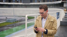 Ritratto del primo piano dell'uomo caucasico attraente che controlla il telefono e che ottiene aria aperta diritta felice e sorpr archivi video Ritratto del primo piano dell'uomo caucasico attraente che controlla il telefono e che ottiene aria aperta diritta felice e sorpr archivi video