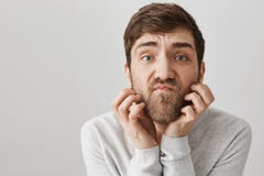Ritratto del primo piano della barba adulta non rasata impacciata di scratch dell'uomo mentre esaminando con lo sguardo insoddisf immagini stock Ritratto del primo piano della barba adulta non rasata impacciata di scratch dell'uomo mentre esaminando con lo sguardo insoddisf immagini stock
