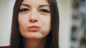 Ritratto del primo piano di bella ragazza felice che mangia una ciambella, godente di uno spuntino sul lavoro stock footage Ritratto del primo piano di bella ragazza felice che mangia una ciambella, godente di uno spuntino sul lavoro stock footage