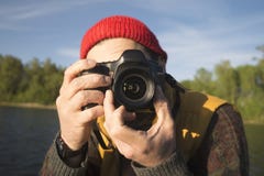 Ritratto del primo piano di un uomo che prende un'immagine con la macchina fotografica professionale della foto su un lago fotografia stock libera da diritti Ritratto del primo piano di un uomo che prende un'immagine con la macchina fotografica professionale della foto su un lago fotografia stock libera da diritti