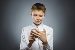 Ritratto del ragazzo di offesa con il cellulare o il telefono cellulare Emozione umana negativa fotografie stock Ritratto del ragazzo di offesa con il cellulare o il telefono cellulare Emozione umana negativa fotografie stock