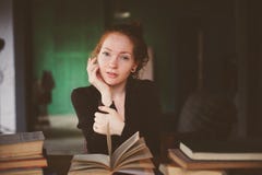 ritratto dell'interno dei libri felici di apprendimento o di lettura della donna della testarossa in università fotografia stock libera da diritti ritratto dell'interno dei libri felici di apprendimento o di lettura della donna della testarossa in università fotografia stock libera da diritti