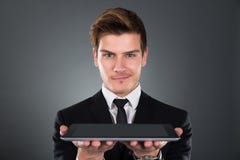 Ritratto dell'uomo d'affari sicuro che tiene compressa digitale immagini stock libere da diritti Ritratto dell'uomo d'affari sicuro che tiene compressa digitale immagini stock libere da diritti