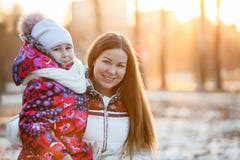 Ritratto della madre caucasica con il bambino, una sera gelida, sole, tramonto Immagini Stock Ritratto della madre caucasica con il bambino, una sera gelida, sole, tramonto Immagini Stock