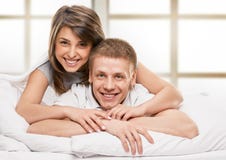 Ritratto delle coppie felici che si trovano a letto fotografia stock libera da diritti Ritratto delle coppie felici che si trovano a letto fotografia stock libera da diritti