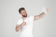 Ritratto di bello uomo con una barba e un'acconciatura alla moda vestite in abbigliamento casuale fare un sephi sulla sua compres fotografie stock libere da diritti Ritratto di bello uomo con una barba e un'acconciatura alla moda vestite in abbigliamento casuale fare un sephi sulla sua compres fotografie stock libere da diritti