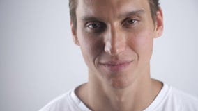 Ritratto di bello uomo sorriso che sorride e che guarda alla macchina fotografica sui precedenti bianchi della parete Fine in su archivi video Ritratto di bello uomo sorriso che sorride e che guarda alla macchina fotografica sui precedenti bianchi della parete Fine in su archivi video