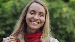 Ritratto di giovane bella donna che indossa in rosso condizione della sciarpa nel parco della città e che esamina la macchina fot video d archivio Ritratto di giovane bella donna che indossa in rosso condizione della sciarpa nel parco della città e che esamina la macchina fot video d archivio