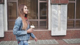 Ritratto di giovane donna alla moda felice che cammina nella città e nel caffè bevente video d archivio Ritratto di giovane donna alla moda felice che cammina nella città e nel caffè bevente video d archivio