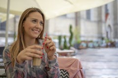 Ritratto di giovane donna bionda attraente in caffè il giorno soleggiato immagini stock Ritratto di giovane donna bionda attraente in caffè il giorno soleggiato immagini stock