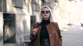 Ritratto di giovane donna bionda attraente nella città di autunno La ragazza ha lo sguardo alla moda, gli occhiali da sole e pier stock footage Ritratto di giovane donna bionda attraente nella città di autunno La ragazza ha lo sguardo alla moda, gli occhiali da sole e pier stock footage
