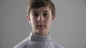 Ritratto di giovani 11 svegli - ragazzo di 12 anni che esamina la macchina fotografica su fondo bianco stock footage Ritratto di giovani 11 svegli - ragazzo di 12 anni che esamina la macchina fotografica su fondo bianco stock footage