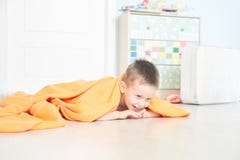 Ritratto di un bambino sveglio in plaid arancio nella casa fotografia stock libera da diritti Ritratto di un bambino sveglio in plaid arancio nella casa fotografia stock libera da diritti