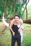 Ritratto di un giovane bello che porta donna attraente sul suo parte posteriore all'aperto Coppie di divertimento Sposa ed il gr fotografia stock Ritratto di un giovane bello che porta donna attraente sul suo parte posteriore all'aperto Coppie di divertimento Sposa ed il gr fotografia stock