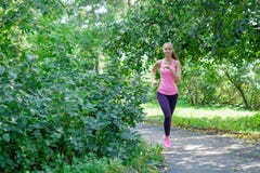 Ritratto di una giovane donna che corre da solo nel parco immagine stock libera da diritti Ritratto di una giovane donna che corre da solo nel parco immagine stock libera da diritti